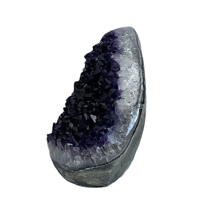 Angled view of Brazilian teardrop amethyst geode showing deep purple crystal clusters and a thick pale mineral rim